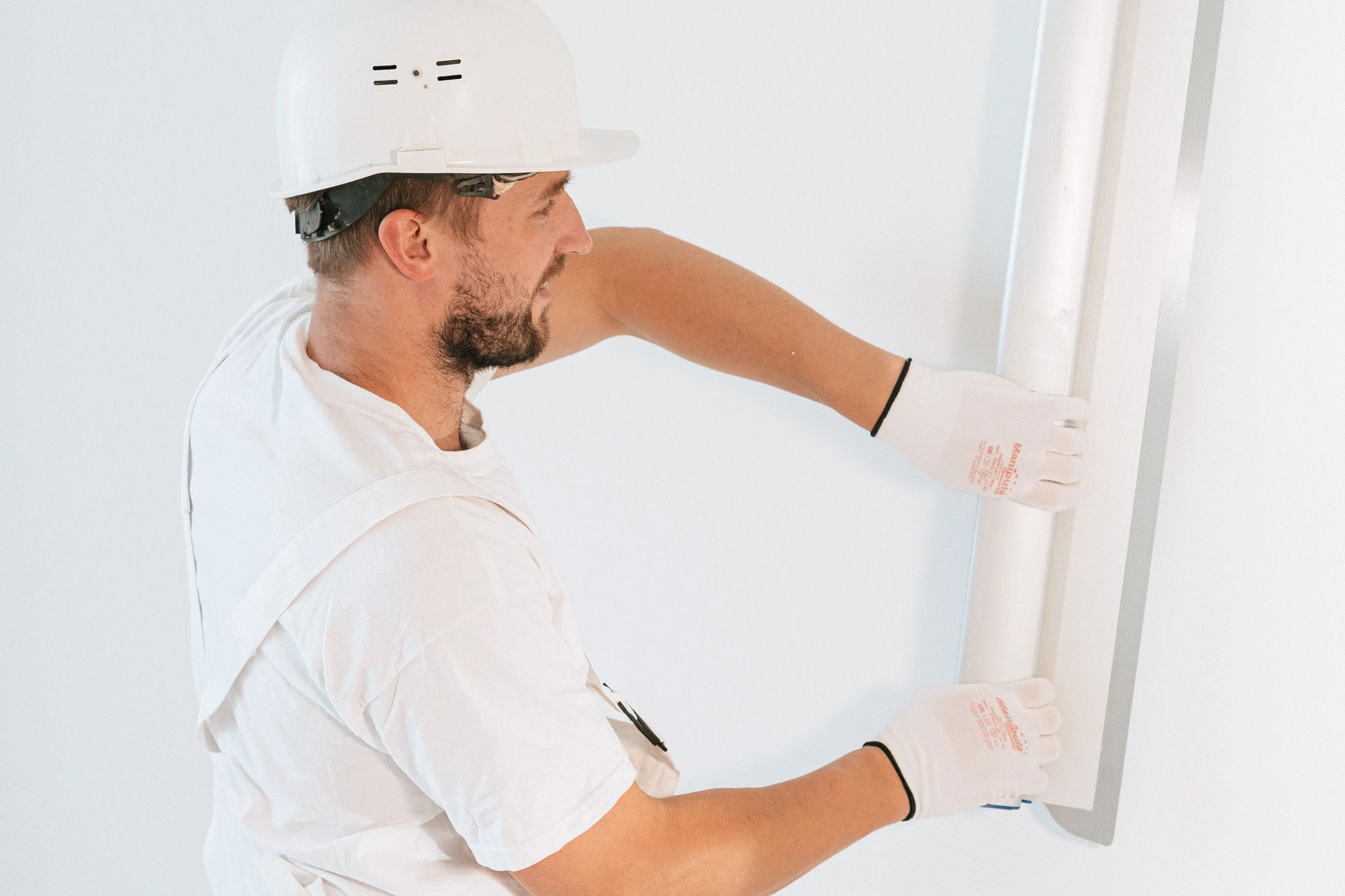 Construction professional repairing interior drywall during property reinstatement