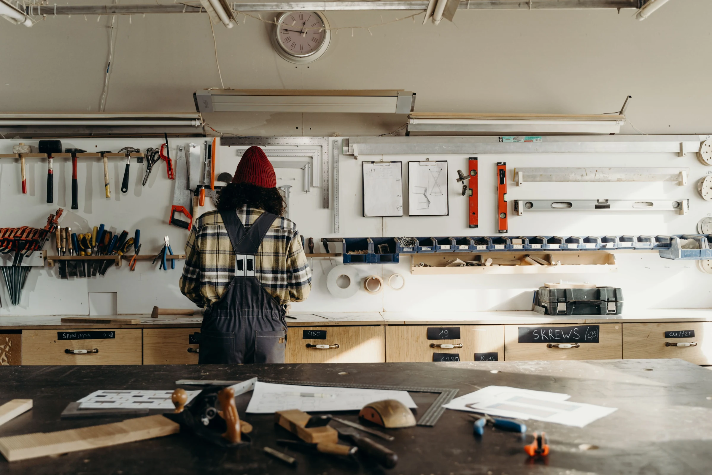 Carpenter working at a timber workbench surrounded by joinery tools